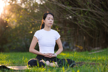 Woman meditating peacefully outdoors in green park