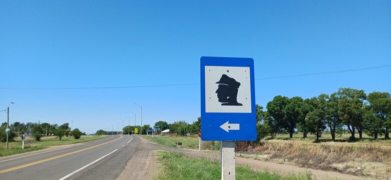 Policia Schild Uruguay &ndash; Polizei Hinweiszeichen an Landstra&szlig;e, blaues Verkehrsschild, l&auml;ndliche Umgebung