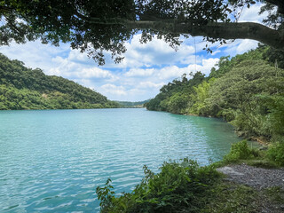 Crystal clear turquoise river flowing through lush green mountain valley in Wulai New Taipei City Taiwan on a sunny morning