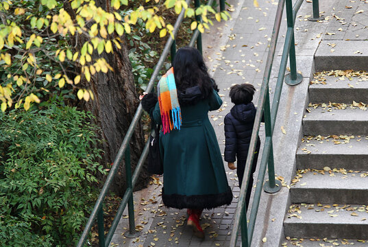 Mujer con abrigo y bufanda de colores en invierno junto a ni&ntilde;o
