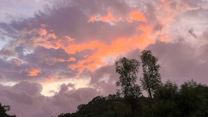 Dramatic dawn sky over Wulai, New Taipei City, Taiwan, featuring vibrant pink, orange, and purple altocumulus clouds above the dark silhouette of the hills and trees.