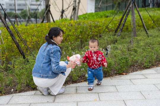 Mother playing with her son using bubble gun