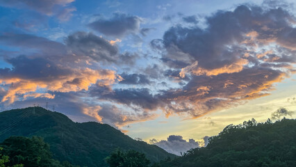 Intense orange and golden sunrise clouds glowing dramatically above the dark mountain ridges of Wulai in New Taipei City Taiwan at early dawn.