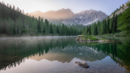 Tranquil alpine lake reflecting majestic mountains and pine forest at sunrise
