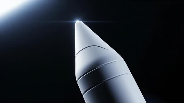 Close up of a white missile or rocket nose cone with a bright lens flare against a dark background