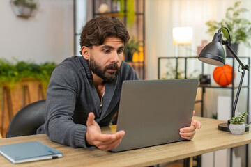 Indian man at home sees laptop program crash error screen glitch freeze facepalm frustrated....