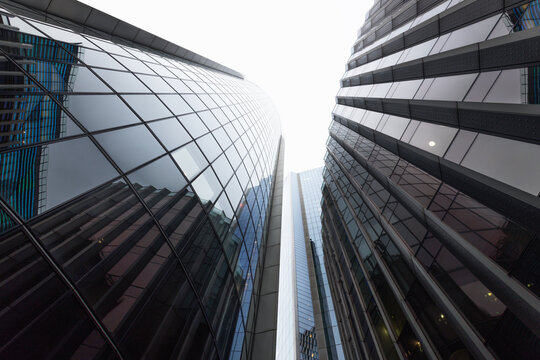 Low angle view of modern skyscrapers reaching to sky in financial district - Powered by Adobe
