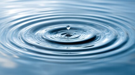 A drop of water falls into a calm lake creating ripples that expand outward. The scene captures a tranquil moment in nature emphasizing serenity and reflection.