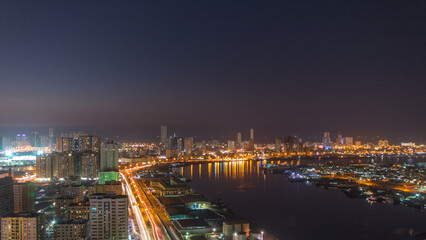Cityscape of Ajman from rooftop day to night timelapse after sunset.