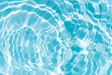 Bluewater waves on the surface ripples blurred. Defocus blurred transparent blue colored clear calm water surface texture with splash and bubbles. Water waves with shining pattern texture background.