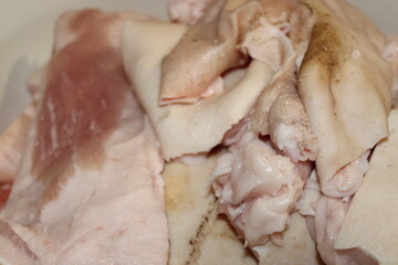 Fresh cuts of pork fat and meat prepared for cooking in a kitchen setting during midday hours
