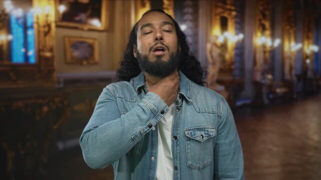 Man with hand on throat for choking inside ornate museum building, eyes closed, denim jacket visible; panic urgency.