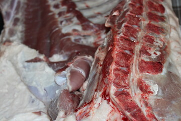 Freshly butchered pork with visible cuts and preparation details in a butcher shop setting
