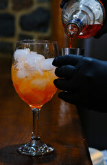 A bartender prepares an aperol cocktail in a glass. Close-up. High quality 4k footage