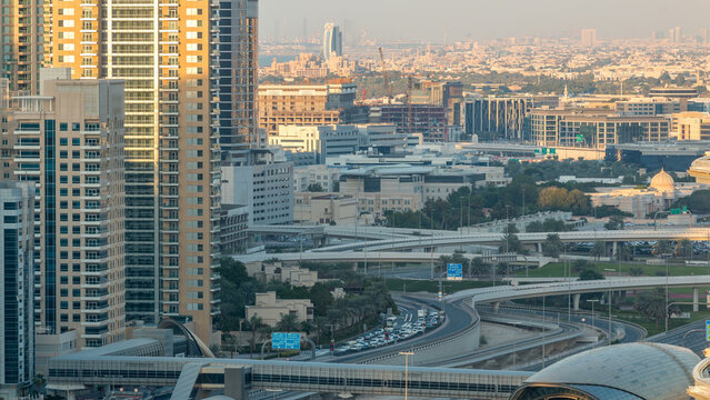 Futuristic building of Dubai metro and tram station and luxury skyscrapers behind timelapse