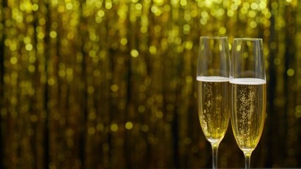 Two glasses of champagne on golden bokeh background.Close up.