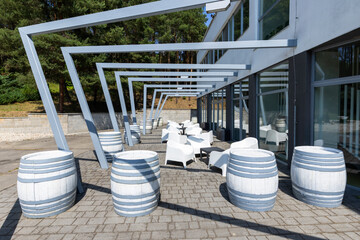 Outdoor terrace with modern pergola structure and barrels
