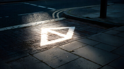 A soft-lit street corner featuring a single turning arrow symbol forming clean simple geometric graphics on pavement