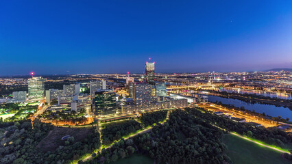 Obraz premium Aerial panoramic view over Vienna city with skyscrapers, historic buildings and a riverside promenade day to night timelapse in Austria.