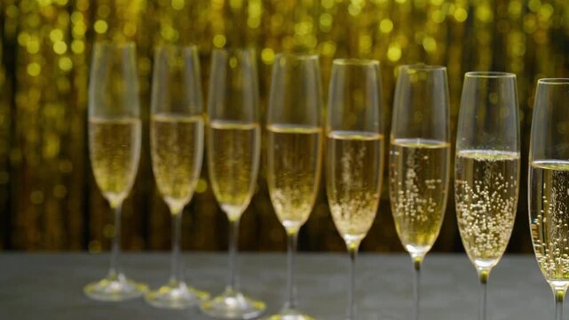 Many glasses of champagne in a line. Row of champagne glasses filled. Lot of glasses filled with champagne are lined up.