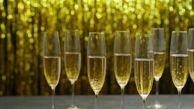 Bubbly champagne wine in a flutes glasses ready to drink in a blurred  holiday bokeh blinking background.
