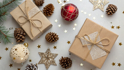 Decorative holiday gifts arranged with festive ornaments and natural elements on a simple background