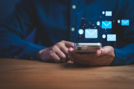 Person using smartphone with email icons symbolizing digital communication, messaging, notifications, online connection, mobile interaction, and modern technology in everyday communication. - Powered by Adobe