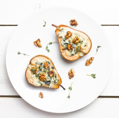 Baked pear with blue cheese, honey, and nuts. Healthy eating. Vegetarian food.