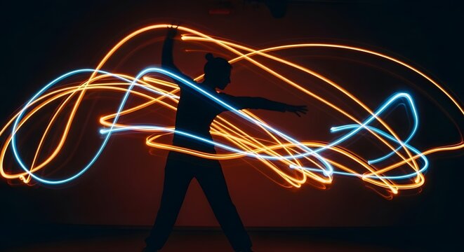 Silhouette of a person performing with light painting, creating dynamic glowing trails in the dark - Powered by Adobe