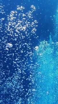 Air bubbles under water. Vertical video