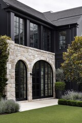 Elegant modern home exterior featuring stone architecture and lush landscaping with green grass in a serene setting during daylight