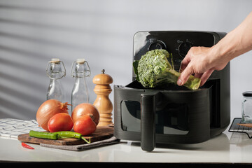 Placing Fresh Broccoli into Air Fryer