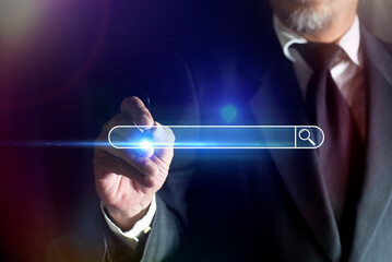 Businessman's hand using a pen touching to search browsing internet data information with blank search bar. SEO search engine optimization technology.