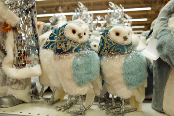 Decorative Christmas plush owls on store counter. Holiday atmosphere.