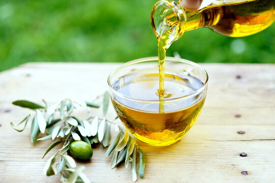 Pouring olive oil into a glass bowl