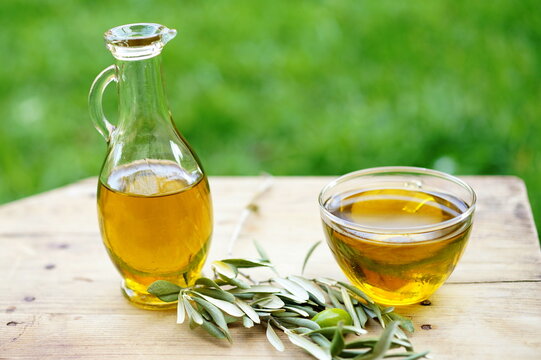Olive oil bottle on wooden table at green background
