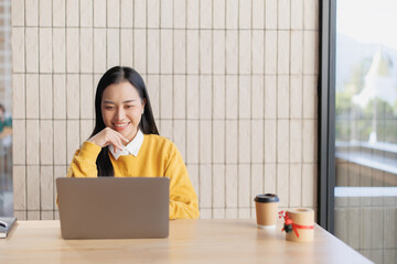 Woman smiling and working on laptop in cafe