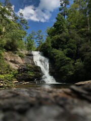Obraz premium Scenic Forest Waterfall Under Blue Sky