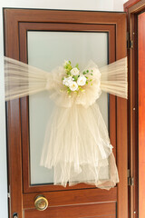 Elegant door decoration with white fabric and floral arrangement for a special occasion