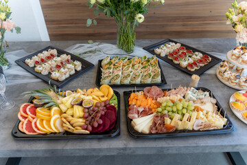 Delicious spread of fresh fruits, savory bites, and sweet treats at a festive gathering in a modern venue