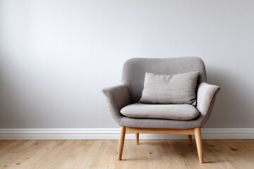 A comfortable gray armchair with a pillow sits on a light wood floor.