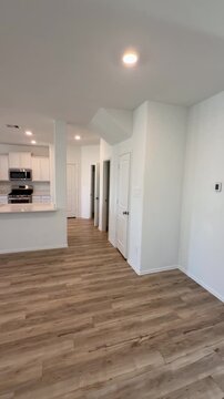 Empty House Interior Open Concept Living Room and Kitchen with Wood Flooring.  