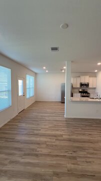Empty House Interior Open Concept Living Room and Kitchen with Wood Flooring.  