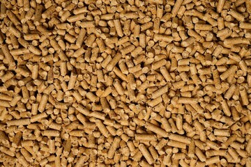 Sawdust pellets scattered on a wooden surface for heating and animal bedding purposes