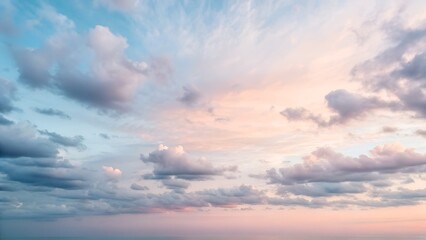 Obraz premium Serene Pastel Sunset Sky With Wispy Clouds Over Calm Ocean Waters