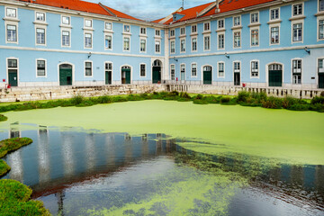 Lake with aquatic vegetation in front of the early 20th-century building that houses the Maritime Police Headquarters. Lisbon, 2023 © Wagner