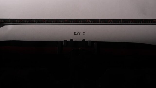 Vintage typewriter stamping day 1 onto white paper, evoking new beginnings, starting a project or journal, creative momentum, nostalgia and the first step of a story