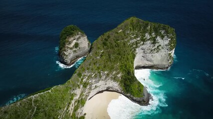 Smooth drone orbit shot rotating counter-clockwise around the iconic Kelingking "T-Rex Head" cliff. Showcases the steep green formation and the secluded turquoise beach below. - Powered by Adobe