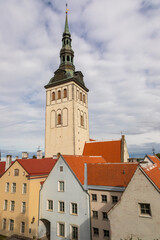 Fototapeta premium Tallinn old town tower rising above colorful historic buildings, Estonia.