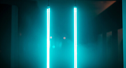 Two bright turquoise neon lights glowing vertically in a dark room creating an abstract futuristic atmosphere